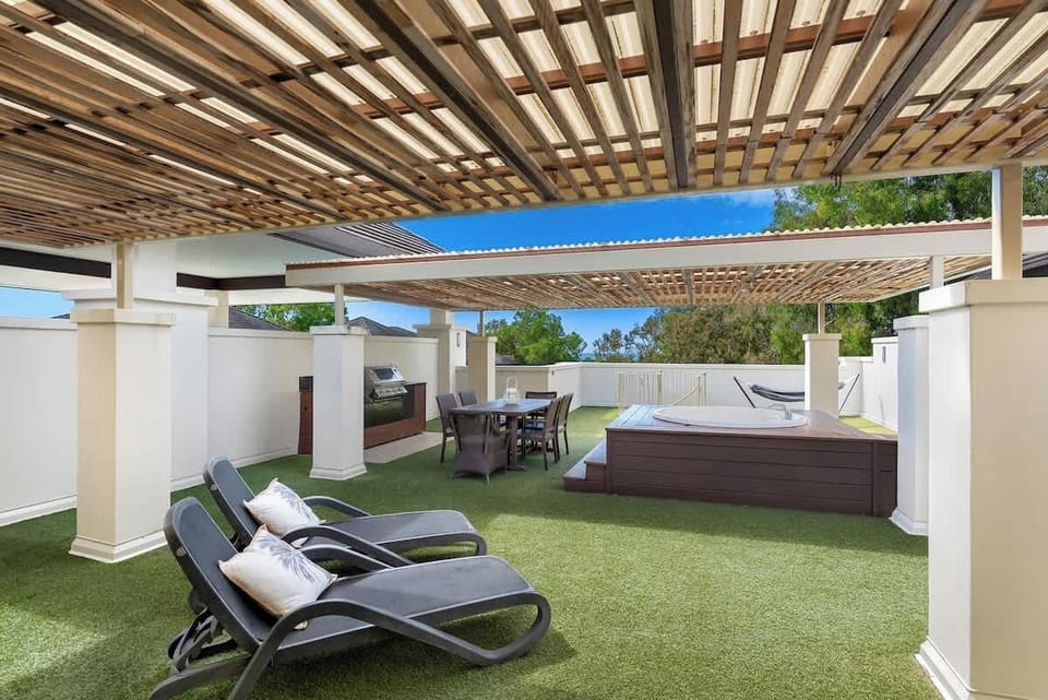 Indulge in the shared rooftop terrace's offerings: day spa, BBQ, sun loungers, and dining area, all with ocean views.