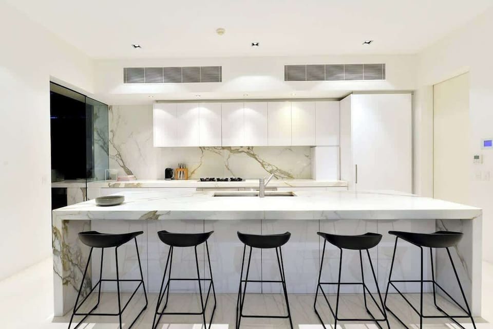 The marble kitchen's oversized island offers ample space to prepare meals or chat with the chef while they whip up dinner.