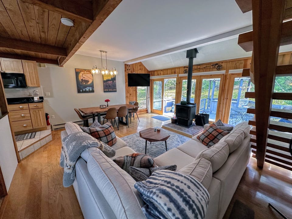 Main living area with dining table, sectional, fireplace and lots of windows!