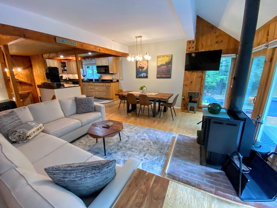 Main living area with dining table, sectional, fireplace and lots of windows!