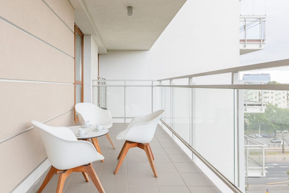 Spacious balcony with outdoor furniture. 