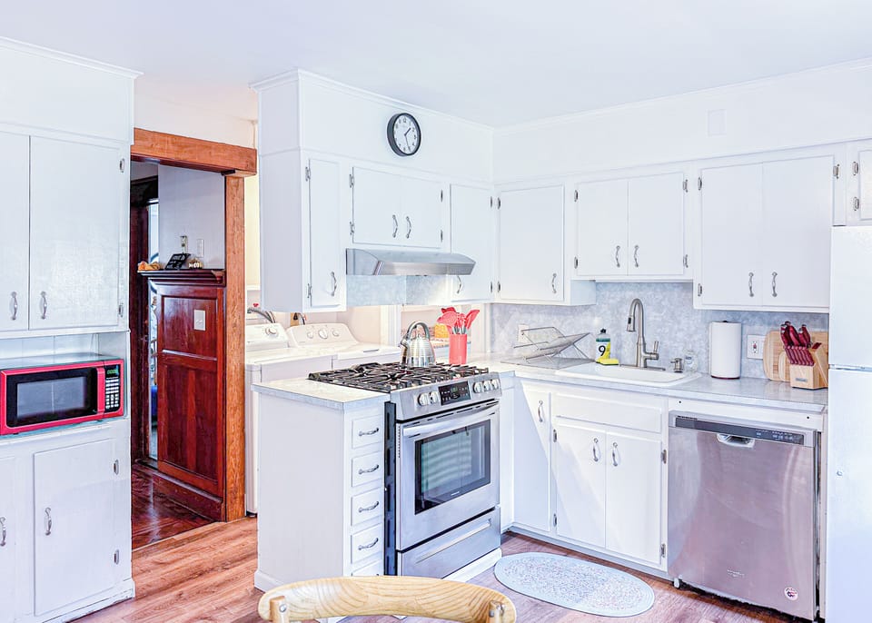 Sleek white cabinets, modern appliances, and a welcoming dining area.