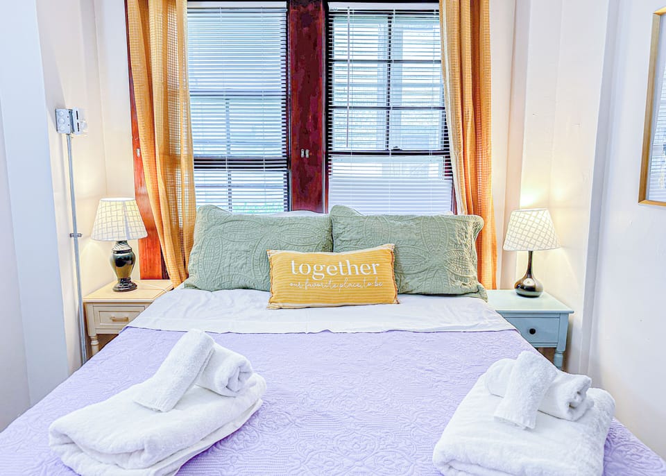 Relax in this charming and sunlit bedroom featuring a comfortable bed.
