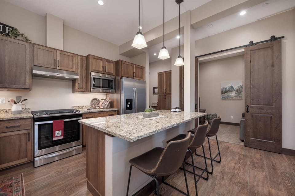 Your spacious kitchen features granite counters, stainless appliances, and a breakfast bar perfect for morning coffee or casual meals together.