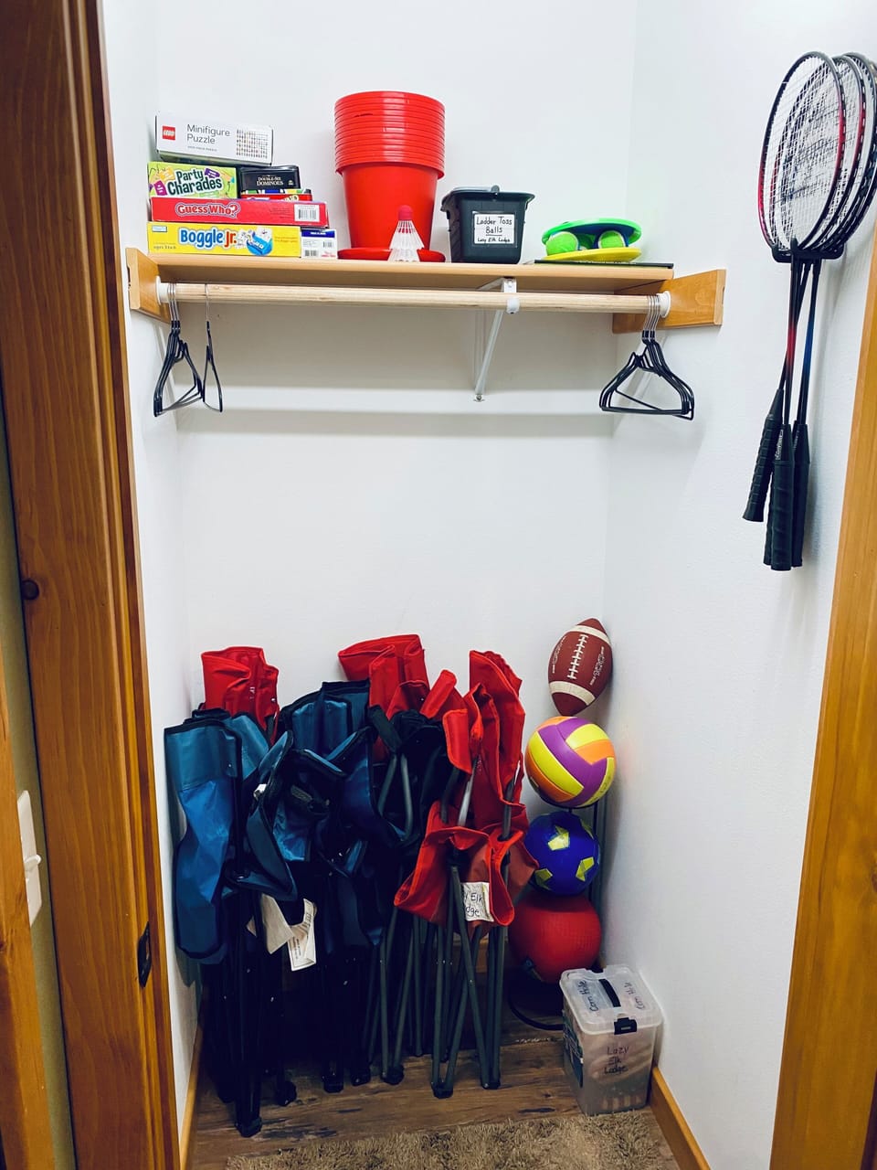 Closet by the front door stocked with cornhole bags, chairs, board games, etc