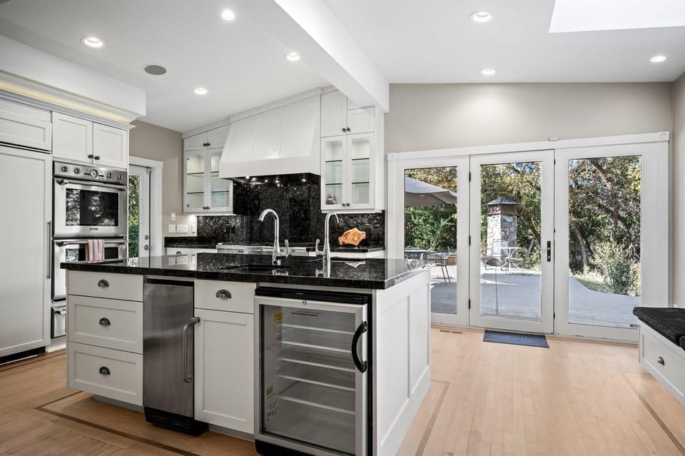 With its modern lighting, windows, quartz countertops, and stunning backsplash, the kitchen makes preparing dinner a truly enjoyable experience.