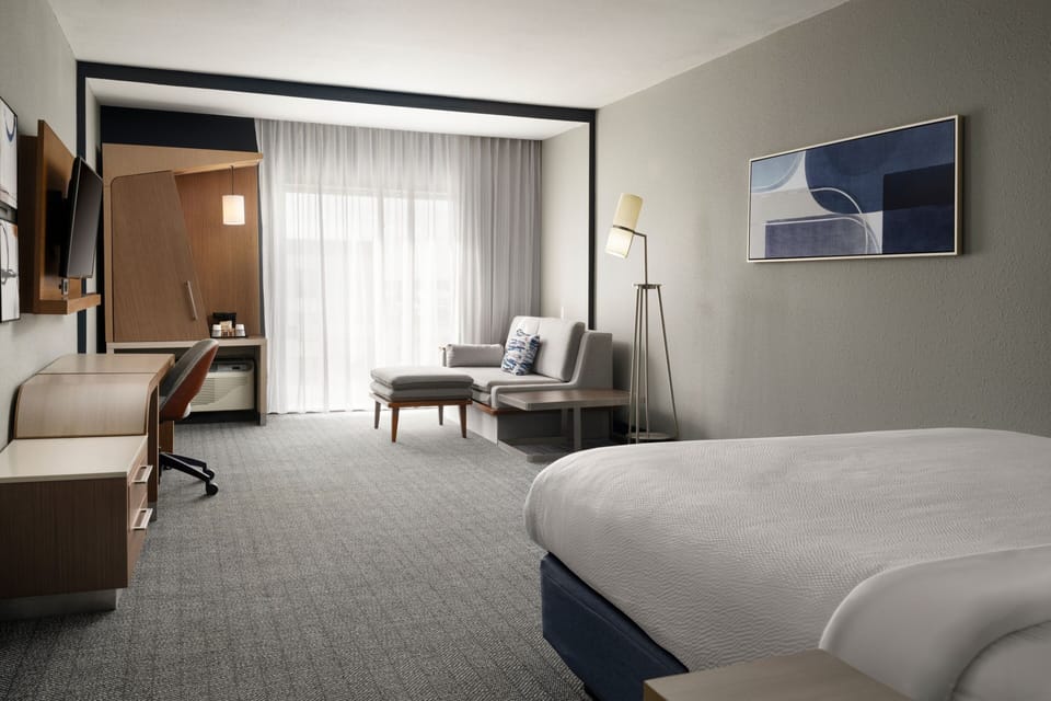 Hypo-allergenic bedding, desk, laptop workspace, blackout drapes