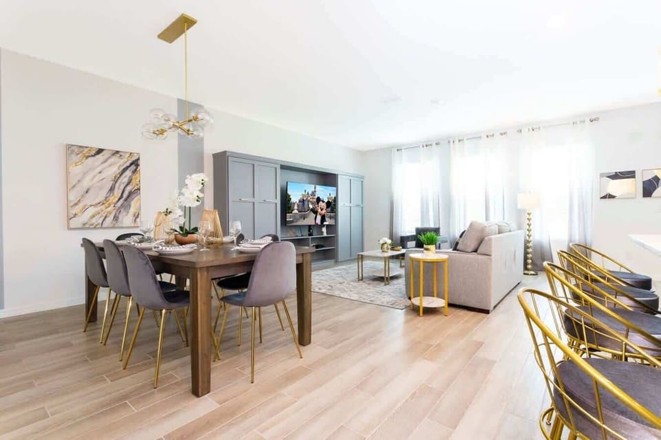 Sunlit open living-relax on the cozy sofa, watch a movie at the entertainment center, then gather at the 8-seat dining table or gold-accented island. Modern, airy, and welcoming.