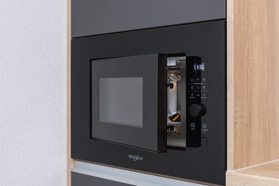 A built-in microwave with a close-up showing the handle and buttons.
