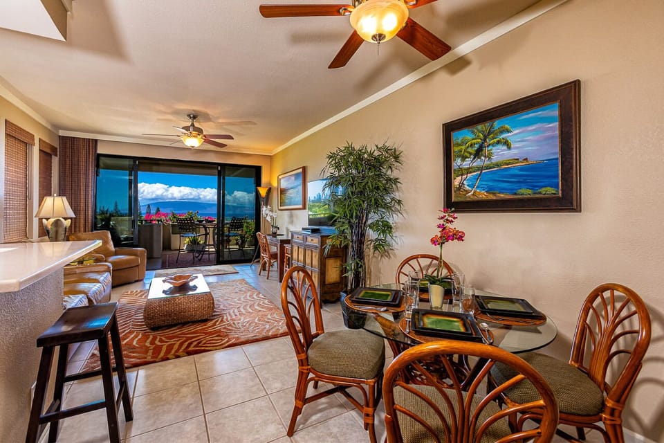 Your inviting open-concept space features tropical decor, comfortable seating, and a dining area where you can enjoy meals with stunning ocean views through expansive sliding doors.