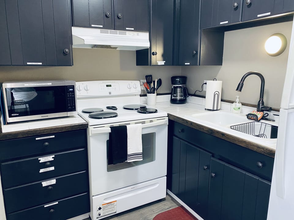 Kitchen with stove/oven, microwave, coffee pot, fridge 