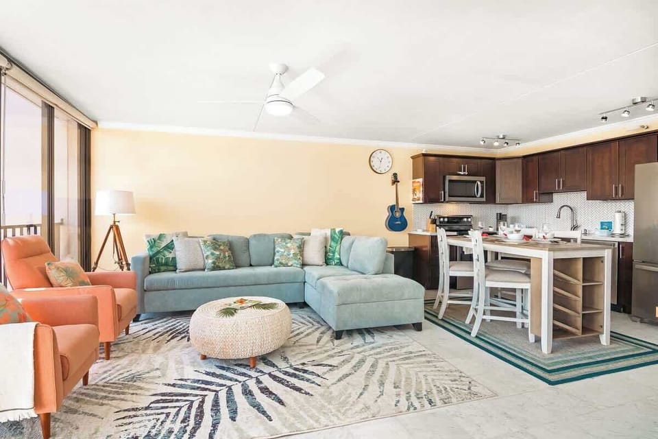 Living room with new sectional pull-out sleeper sofa, rattan round coffee table, and 2 accent chairs.