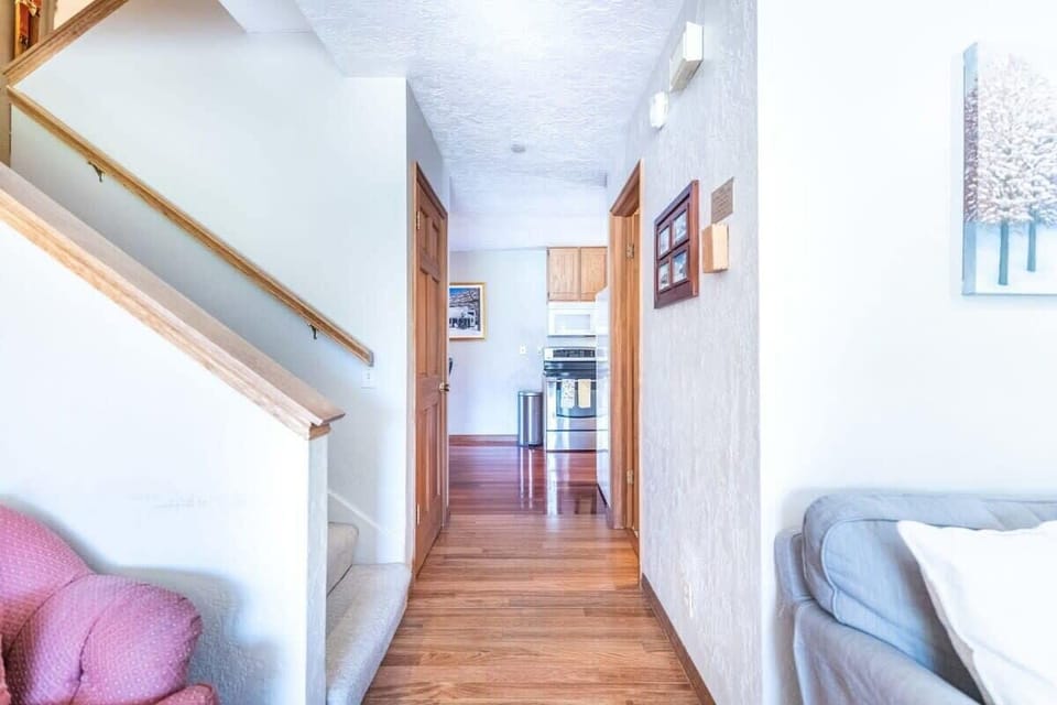The view down the hallway from the living room looking into the dining and kitchen space.