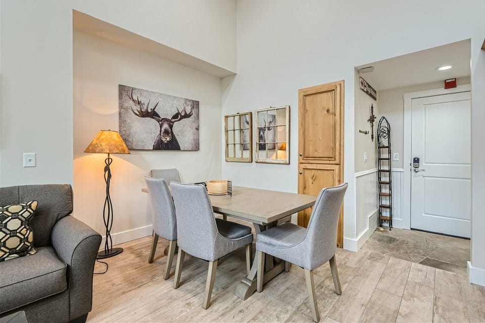 - Gather around the wooden dining table with padded chairs for up to four guests
- Charming moose art and vintage style mirrors add character to the cozy corner
- Perfect for shared meals, board games, or morning coffee chats