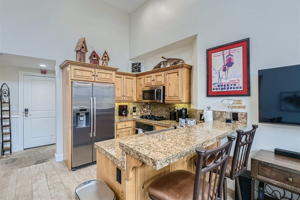 - Spacious kitchen with modern appliances and wood cabinetry  
- Breakfast bar seating perfect for casual dining or morning coffee  
- Well-stocked setup ideal for extended stays or group getaways