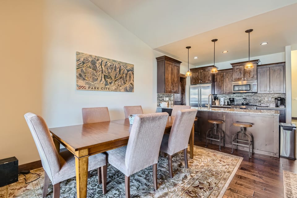 - Elegant dining area with seating for six beside Park City artwork  
- Open layout flows into kitchen with granite counters and pendant lights  
- Perfect space for shared meals and gatherings after mountain adventures