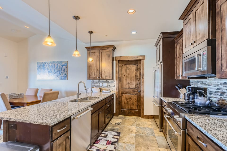 - Gourmet kitchen with double oven and modern stainless steel appliances  
- Long granite island with sink and seating for cooking and dining  
- Stylish tile backsplash adds charm to the rustic wooden cabinets