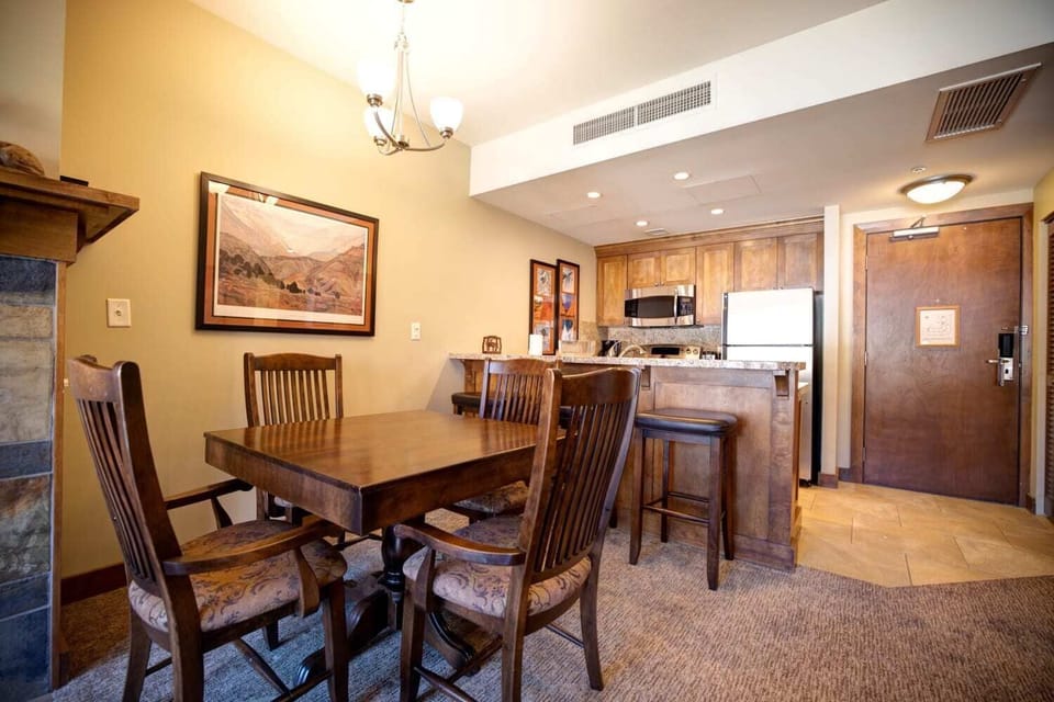 Dining table with seating for group meals, plus additional breakfast bar seating at the kitchen counter.
