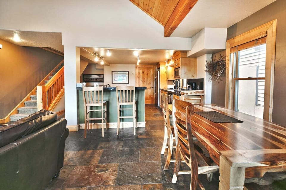 - Dining room with wood table and seating for six  
- Breakfast bar with extra seating for casual meals  
- Warm rustic floors and open kitchen connection
