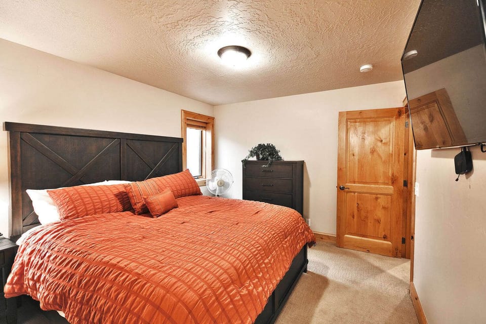 - Bedroom with king bed and bold accent bedding  
- Flat screen TV and dresser for added comfort  
- Cozy retreat with warm wood details throughout