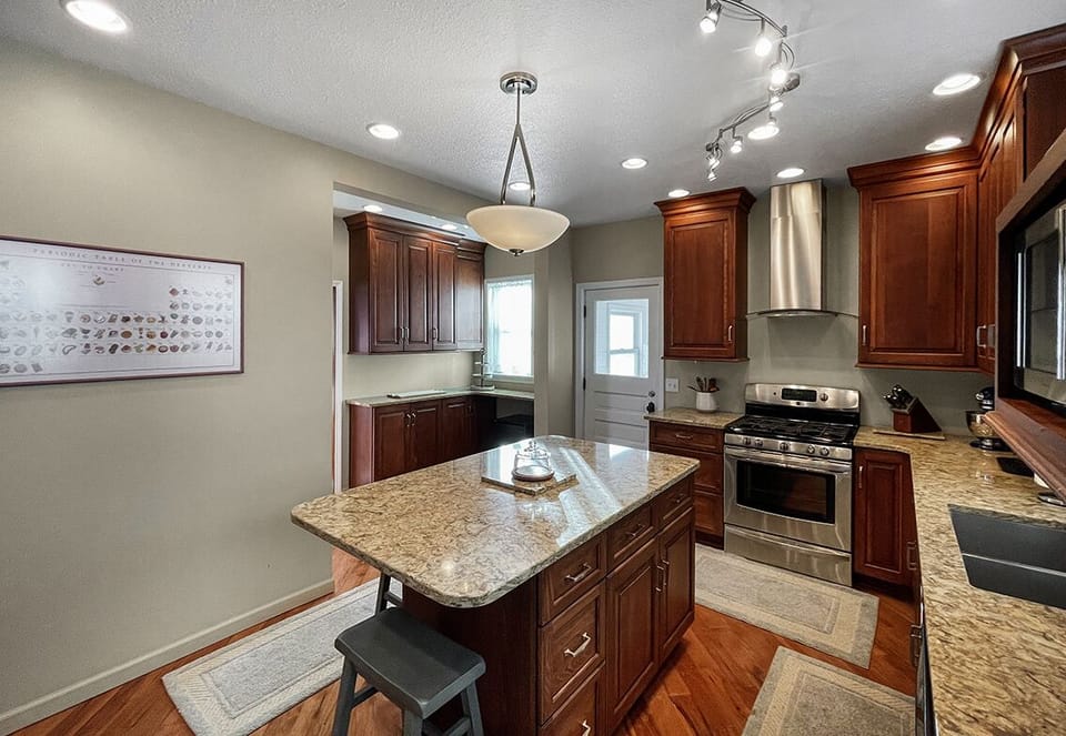 Large kitchen with gas stove and oven and microwave.