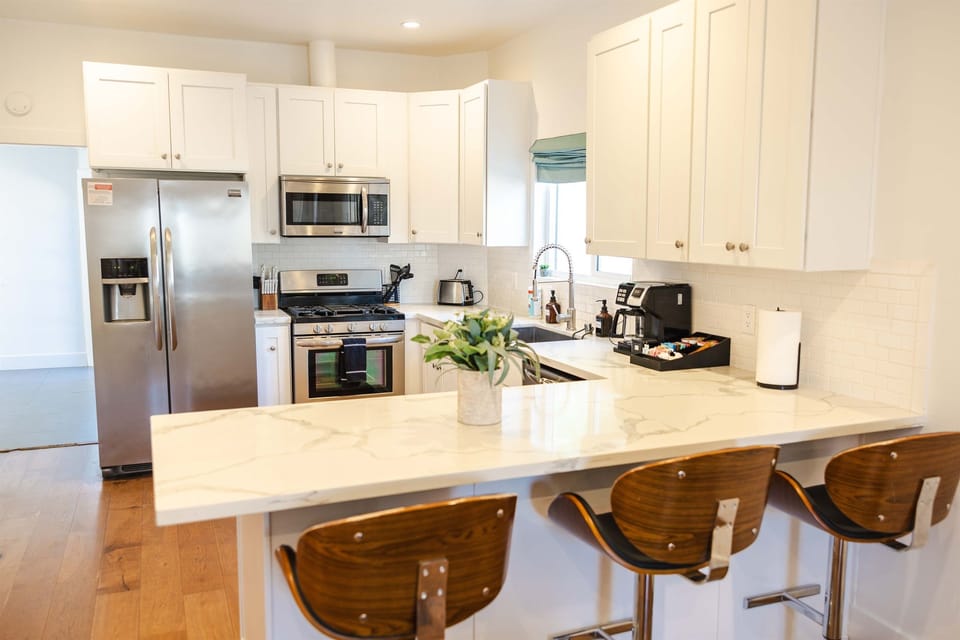Full kitchen with fridge with ice maker, gas stove, microwave, sink, dishwasher, coffee station and misc cooking items. Including 3 chairs to eat at. 