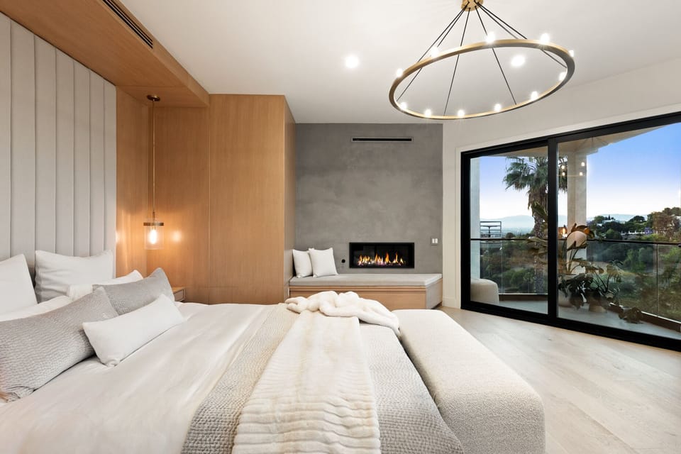 master bedroom with fireplace, balcony and view