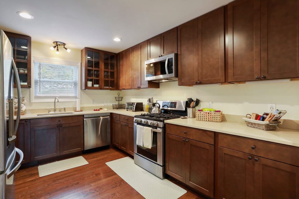 Kitchen with gas stove, large fridge, microwave, utensils, toaster oven, and etc