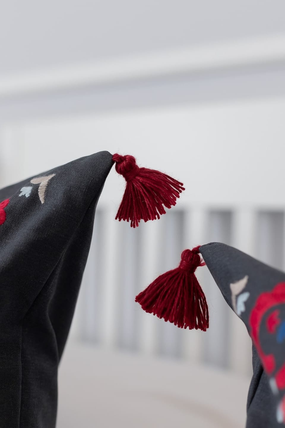 A detailed close-up of tassels and fabric, likely part of a decorative pillow or furniture piece.

