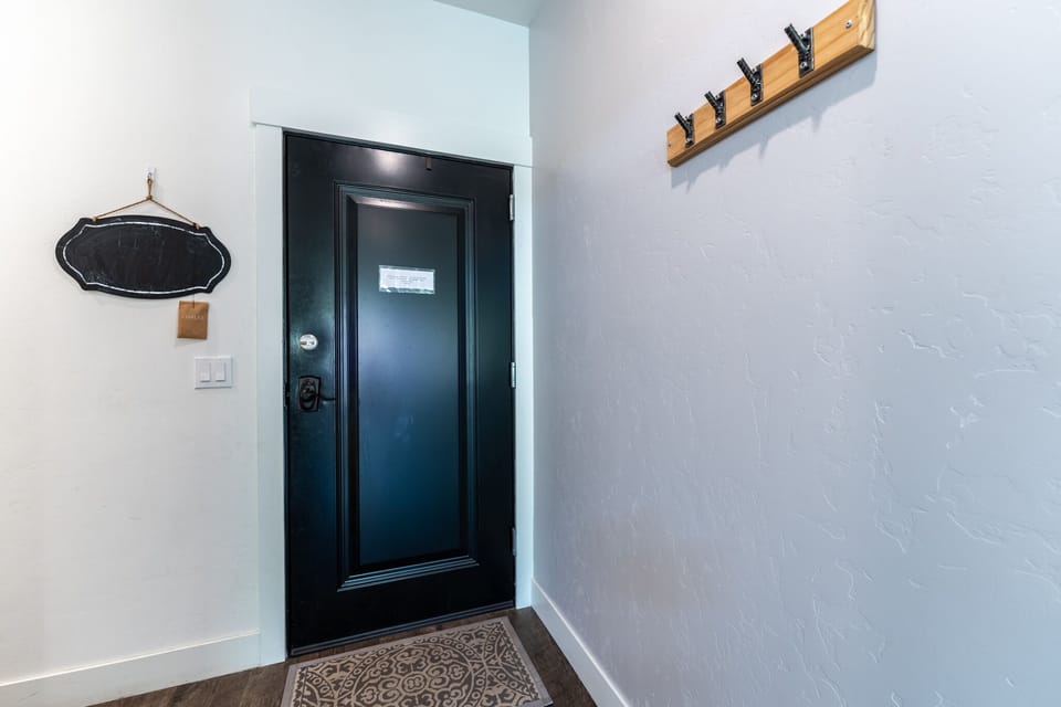 Step into your welcoming entryway with convenient wall hooks for your coats and bags, plus a charming chalkboard for notes.