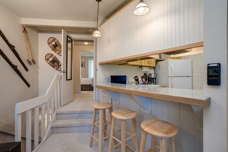 Your cozy kitchen features a granite breakfast bar with wooden stools, perfect for morning coffee or casual meals.