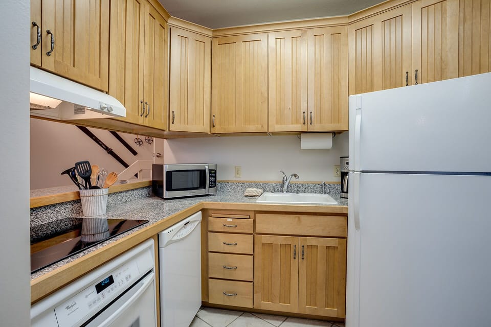 Your fully equipped kitchen features warm wood cabinetry, granite counters, and modern appliances for cooking memorable meals together.