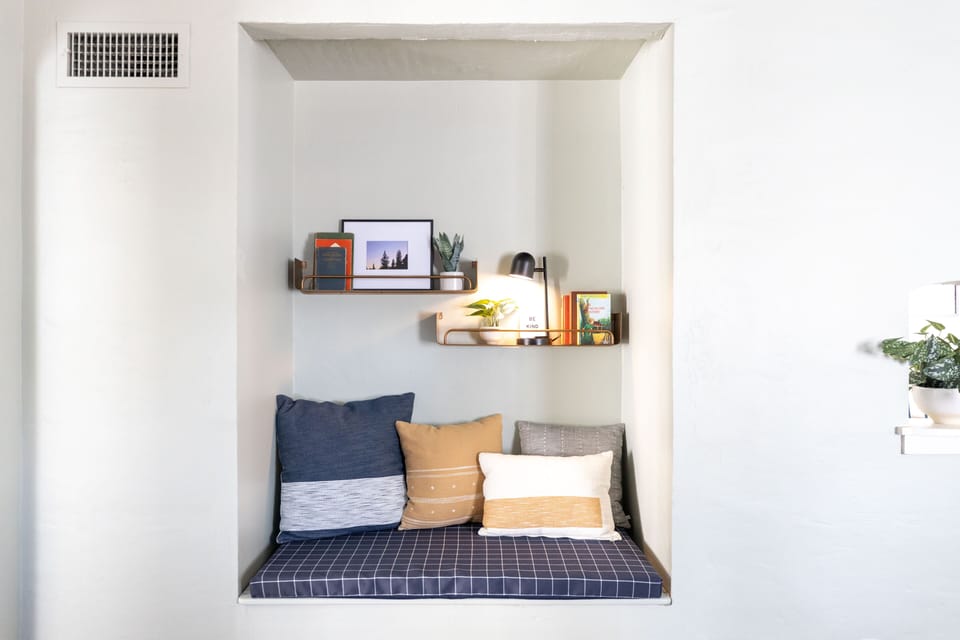 Book nook with kids' activities under bench seat: toys, coloring supplies, books