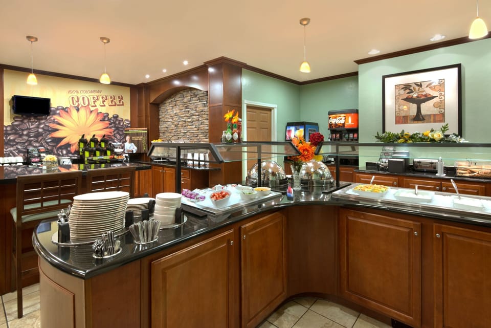 Complimentary breakfast area with coffee, pastries, and fresh options.