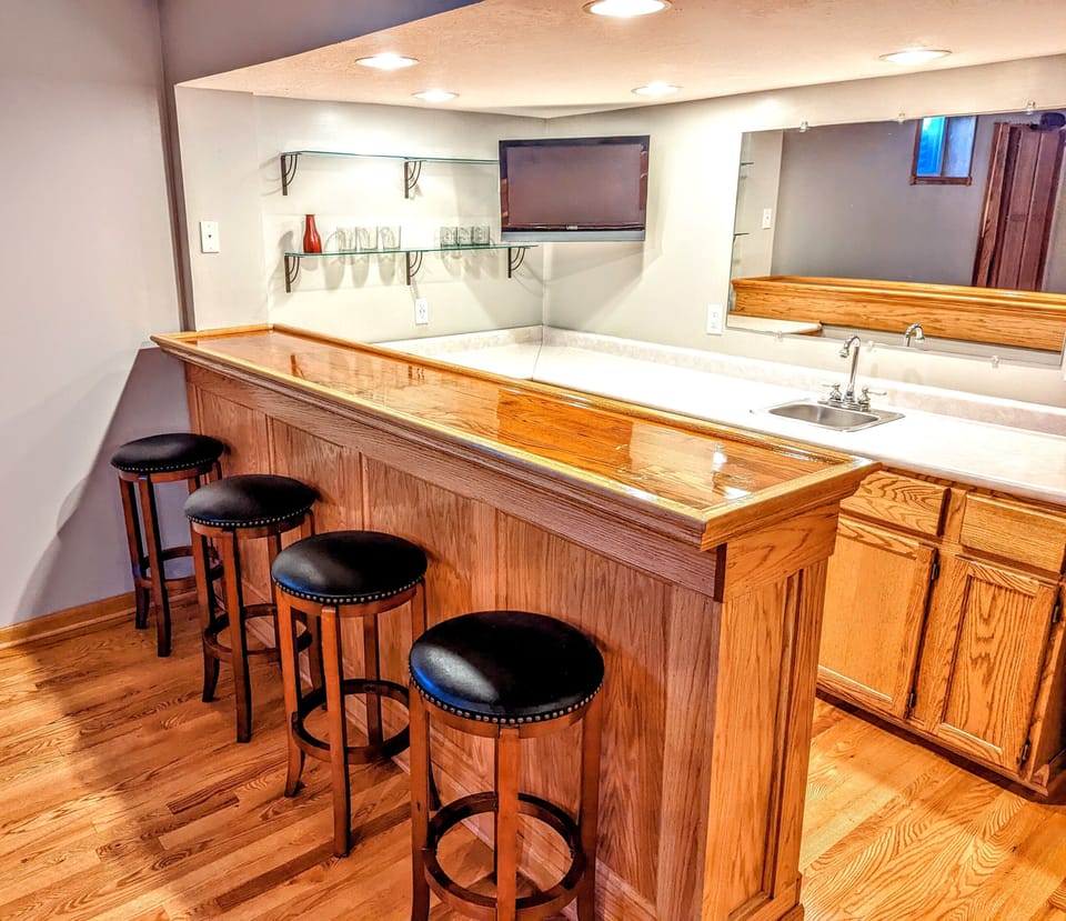 Lower level wet bar area with mini fridge and smart TV