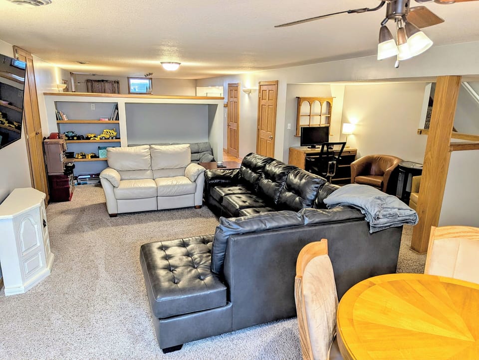 Lower level living w/ kids toys, workstation, card/bumper pool table, & seating.