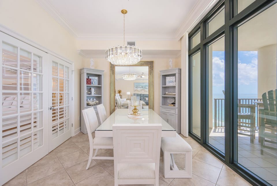 Savor family time at the elegant dining table, where laughter and conversations flow seamlessly into stunning coastal views