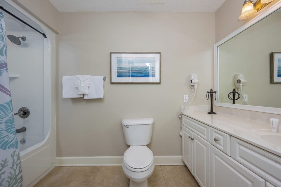 Refresh in this guest bath, featuring a refreshing shower and soft towels for your rejuvenating beach retreat