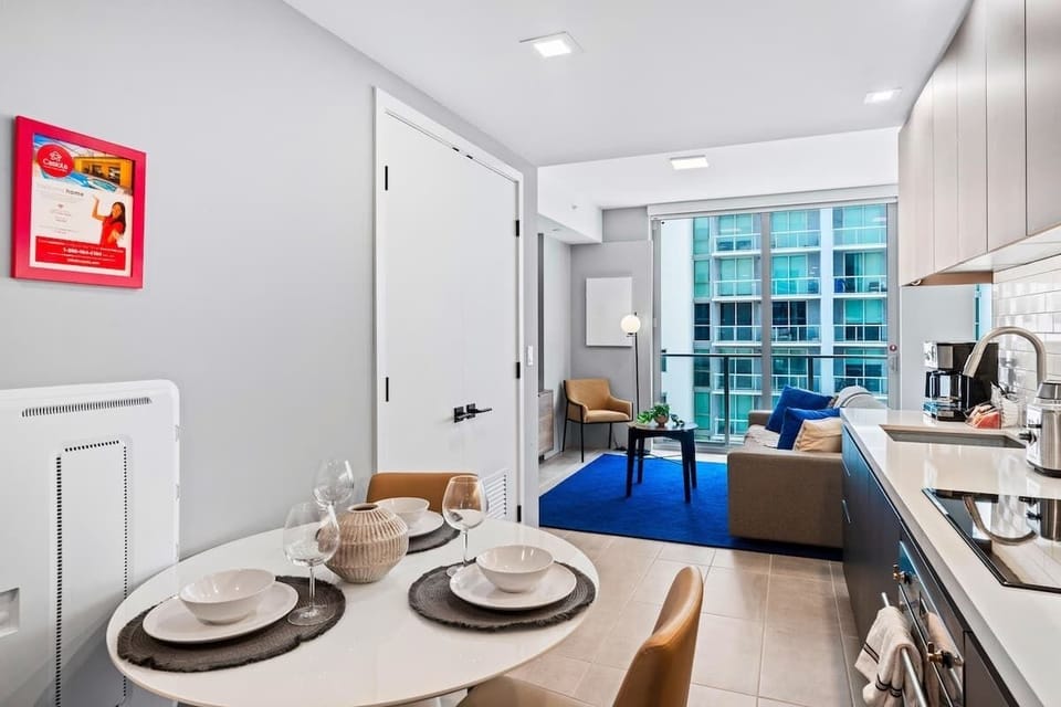 The property features a modern kitchen with an aesthetic appeal. It is fitted with stainless steel appliances, a 4-seater dining table, a coffee maker, and a dishwasher.