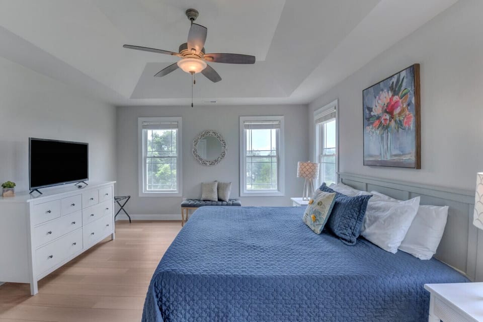 Primary bedroom has plenty of space to stretch out and a TV for winding down privately after a memorable day