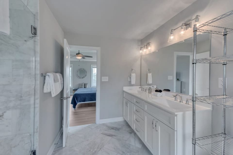 The primary bathroom with double vanity, marble floor and shower is something right out of a magazine