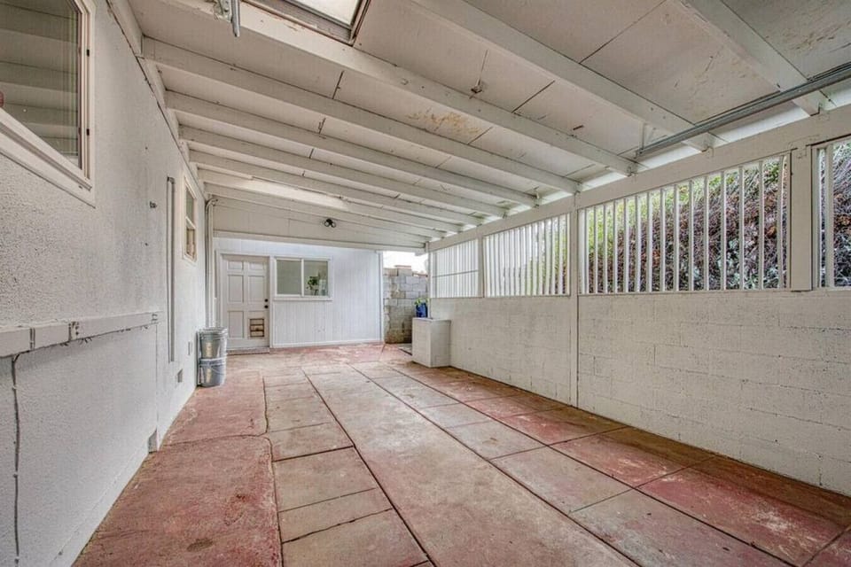 The driveway is on the right side of the property and there is a carport with a garage door for 1 covered parking spot.