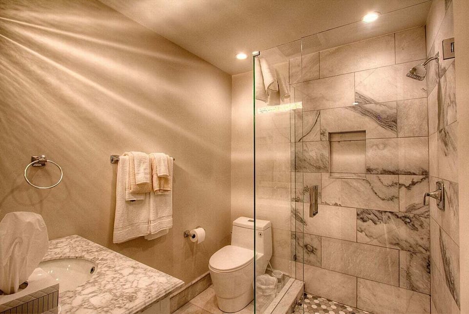 Bathroom with a walk-in shower, a wall niche and a vanity.