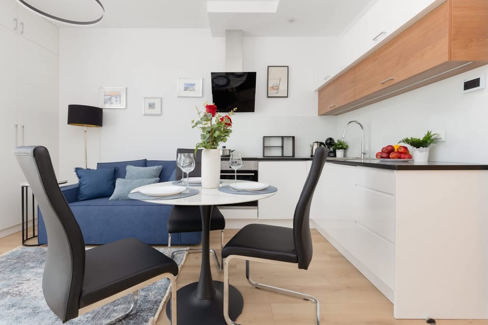 A spacious, open-plan layout connecting the living and dining areas with light wooden floors.
