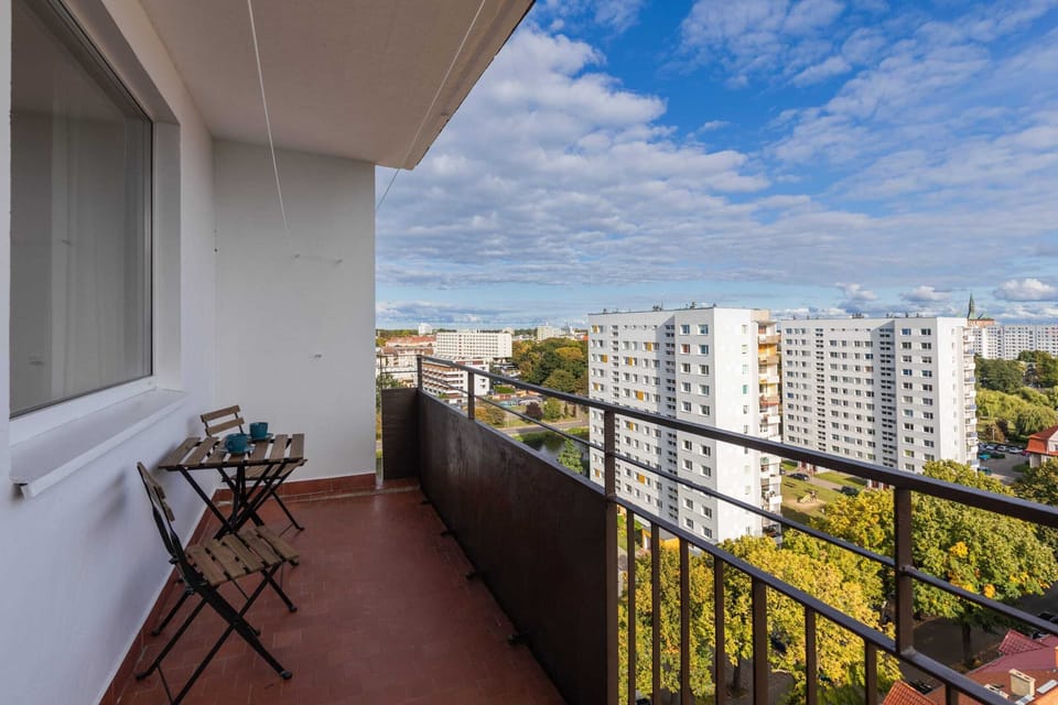 A balcony view featuring outdoor furniture and a scenic cityscape in the background.
