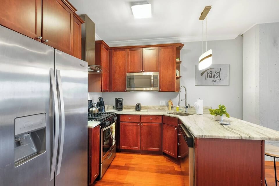 Premium kitchen with stainless refrigerator, dishwasher, microwave, and generous counter space.