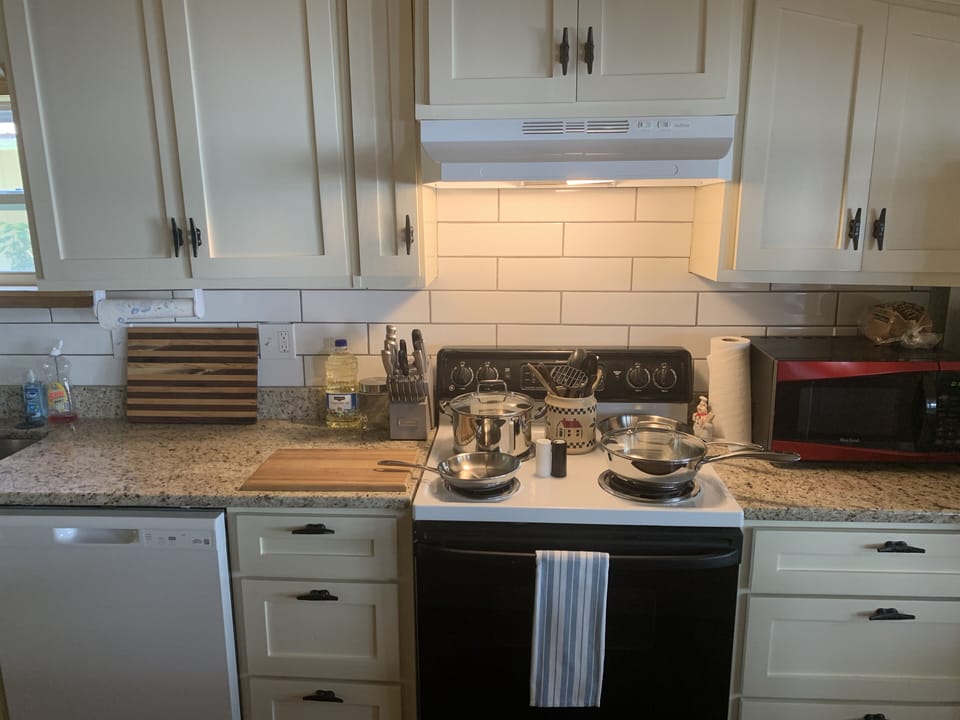 Fully stocked kitchen with pots, pans, cutting boards, knives, microwave, etc.