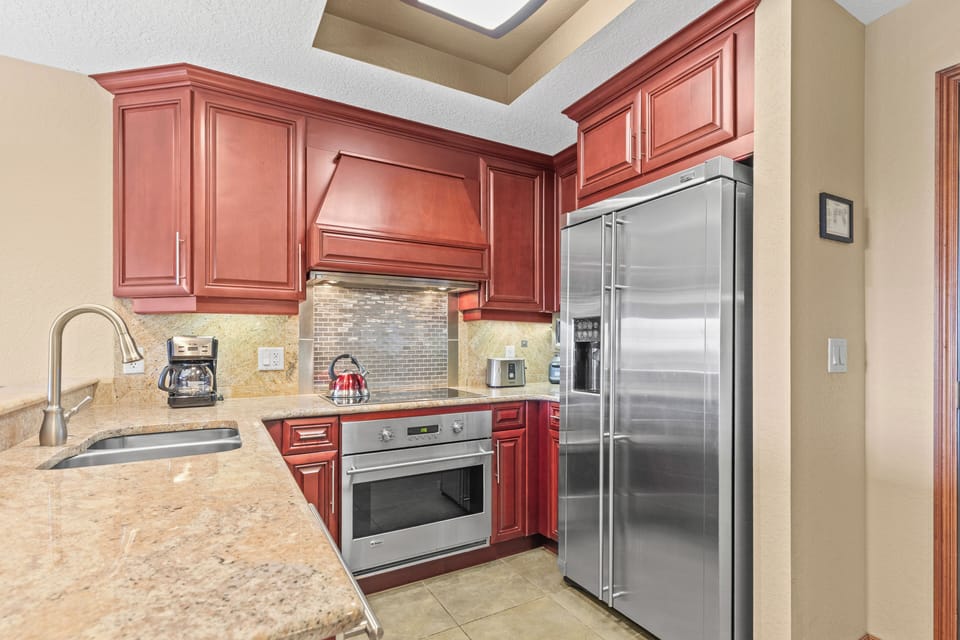 Your fully equipped kitchen features rich cherry cabinetry, granite countertops, and premium stainless steel appliances.