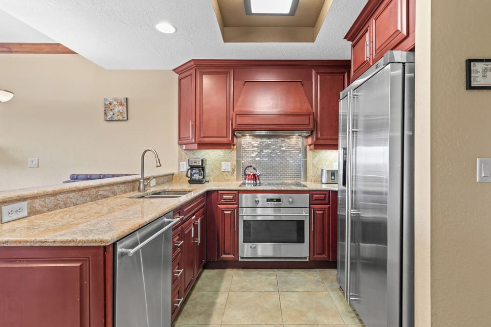 Your fully equipped gourmet kitchen features rich cherry cabinetry, granite countertops, and stainless steel appliances.