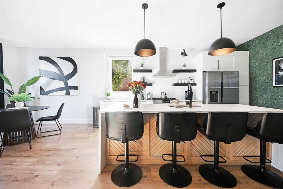 Clean and Spacious Kitchen with Sleek Countertops and Additional Seating